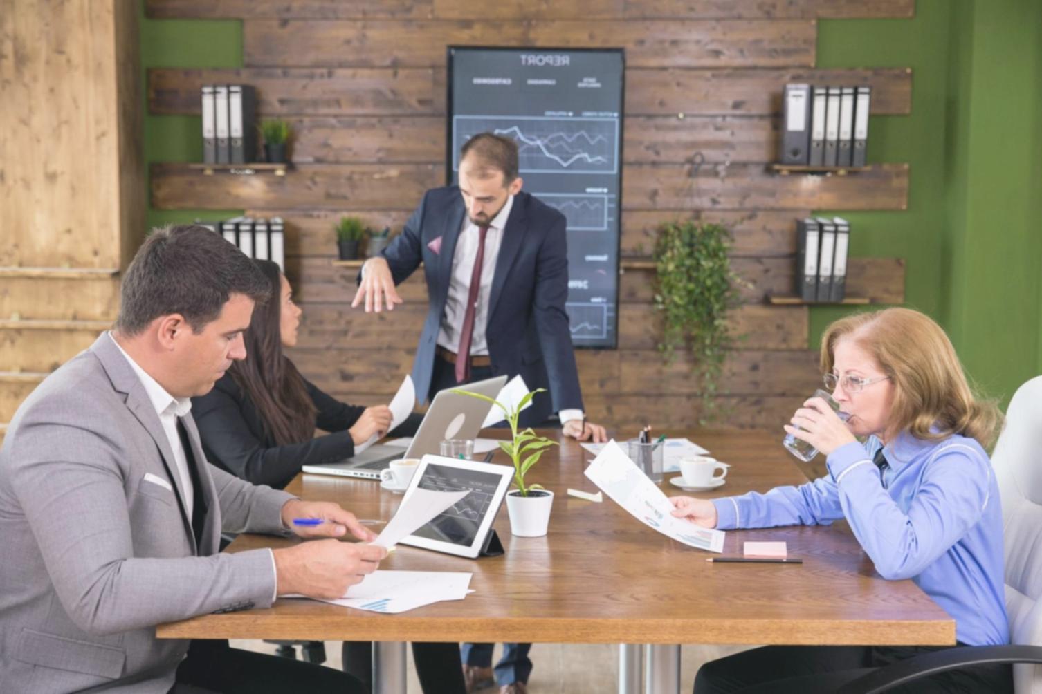 Students analyzing financial documents and business reports in classroom setting